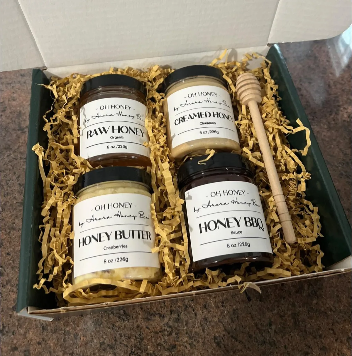 A gift box of four jars with a wooden dipper